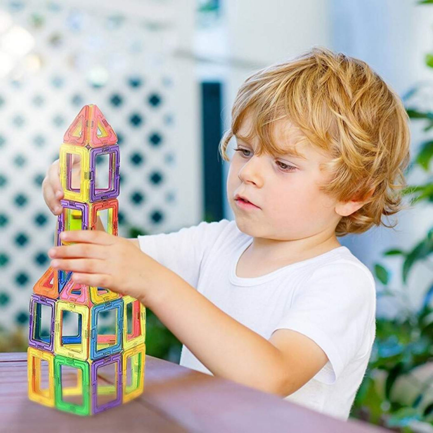 Sensorii's toys- Boy building a rocket ship with Sensorii's magnetic shapes  