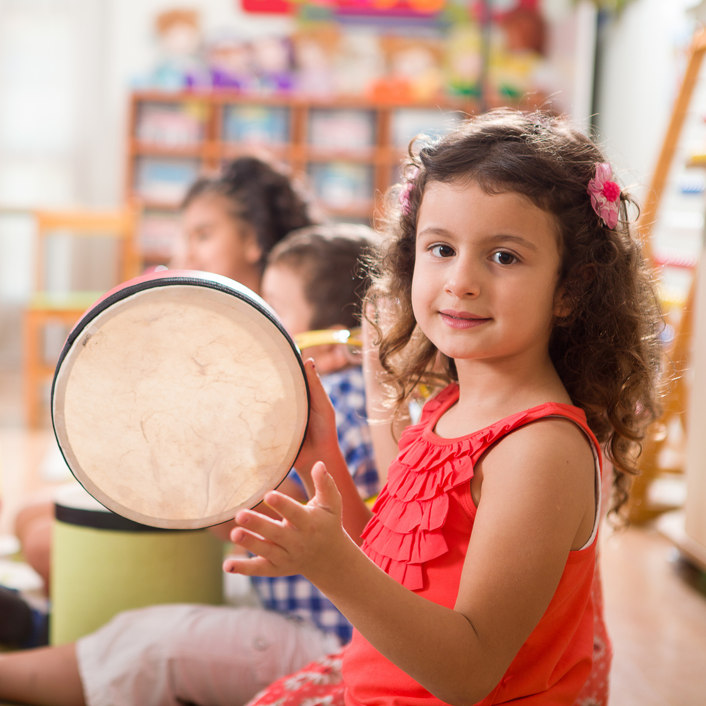 Sensorii's musical instruments- girl in a classroom playing Sensorii's tambourine 