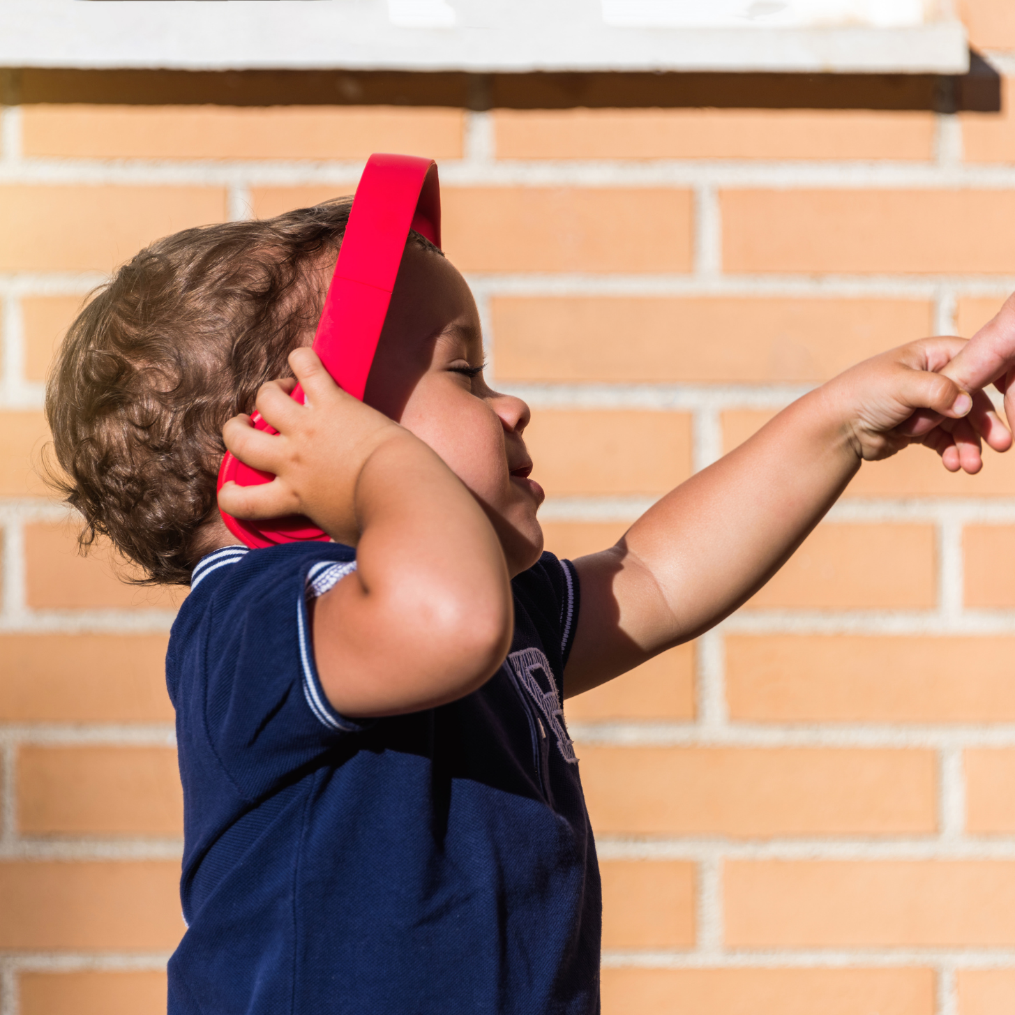 Sensorii's ear protection- boy wearing Sensorii's ear defenders in red 